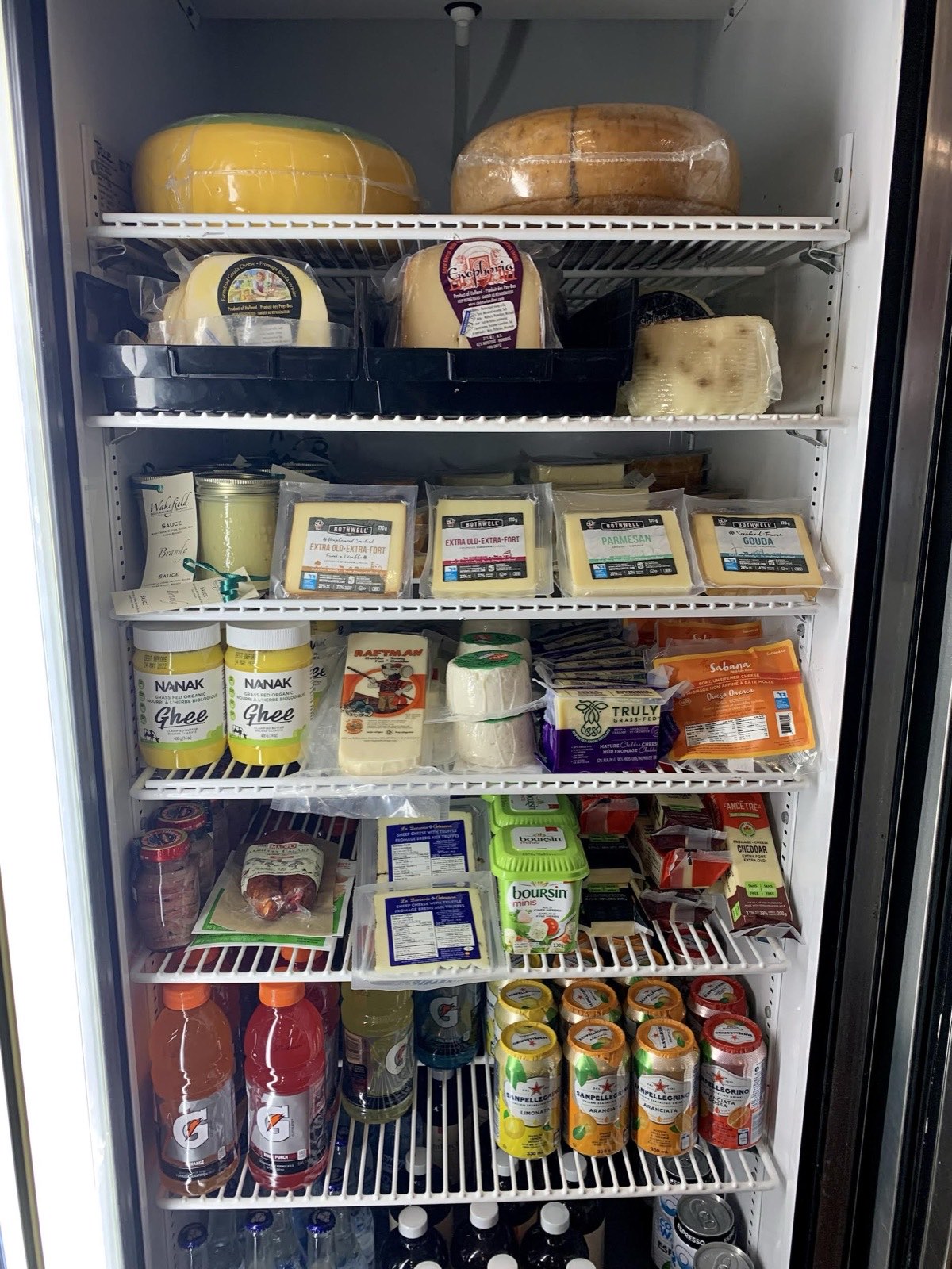 The retail fridge stocked with cheeses, spreads and local drinks